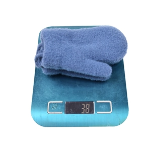 Blue fuzzy knit thermal gloves for toddlers weighed on scale at 38 grams