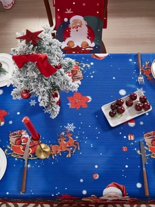 Christmas tablecloth with reindeer pattern and festive chair covers in a cozy setting