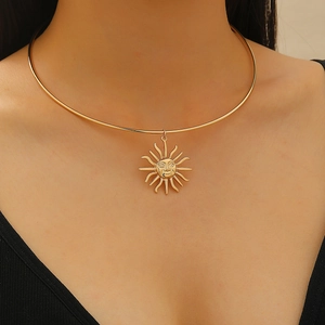 Detailansicht einer goldenen Sonnenkette mit strahlendem Anhänger an einem Halsreif