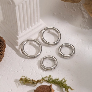 Macro view of silver stainless steel spring ring clasps in two sizes on a white surface