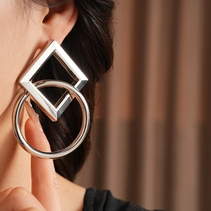 Gros plan de boucles d'oreilles géométriques en argent avec design entrelacé