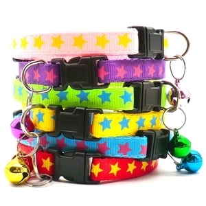 Detail of colorful fabric pet collars with star patterns, bells, and quick-release buckles