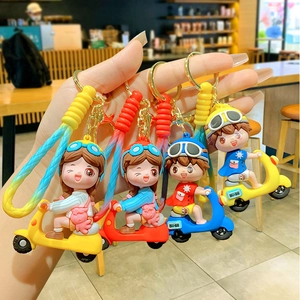Cartoon motorcycle rider keychains in colorful PVC material held for display