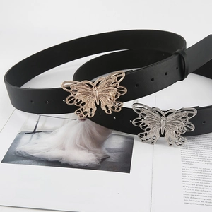 Close-up of black leather belts featuring gold and silver hollow butterfly buckles