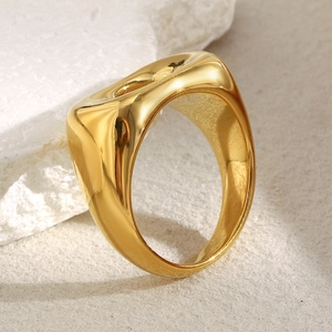 Macro shot of an 18K gold plated hollow bread ring on a natural white stone base