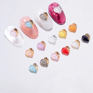 Flat lay of colorful heart-shaped nail charms with gold borders on a clean background