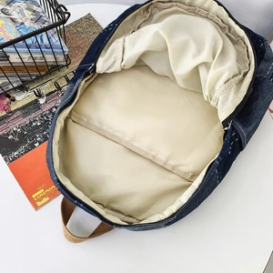 Vintage wash denim backpack with open interior compartment and beige lining