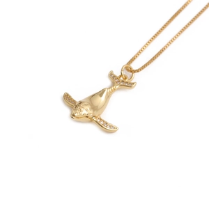 Gold plated dolphin necklace with micro paved zircon crystals on a plain white background