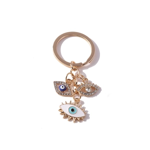 Golden evil eye keychain with blue enamel pendants and sparkling rhinestones