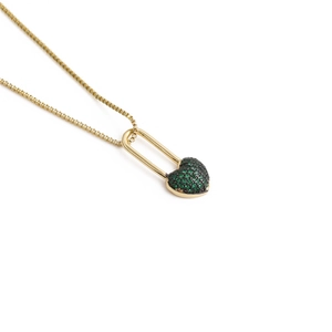 Macro detail of golden box chain with a green crystal heart lock pendant necklace