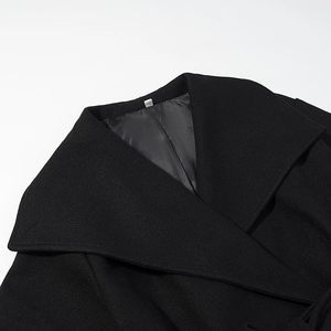 Close-up of a women black wool coat featuring wide lapels and premium fiber texture