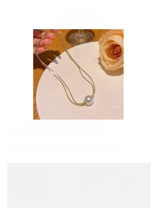 Detail of double-layer titanium steel necklace with a 1.5cm pearl pendant in gold