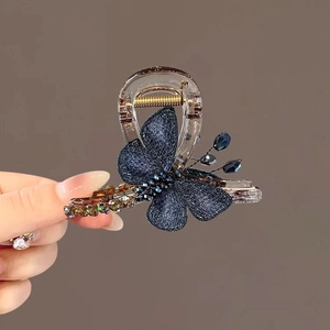 Close-up of embroidered butterfly hair claw with navy fabric and crystal bead details