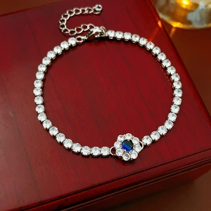 Detail of silver flower bracelet with blue zircon center stone and lobster clasp closure