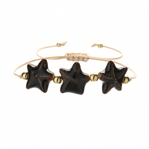 Detailed view of handmade woven bracelet with starfish ceramic beads and gold accents