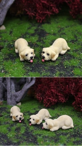 Macro detail of resin Labrador puppy figurines showing realistic fur texture in moss decor