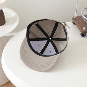 Interior detail of kids hip-hop cap showing reinforced black seams and MONYEAR brand label