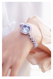 Close-up of luxury women's silver watch with diamond bezel and Roman numerals
