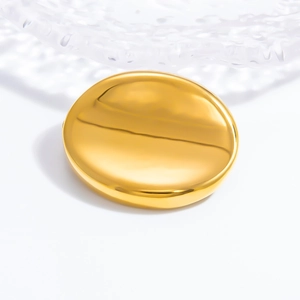 Detailed close-up of a polished gold sun brooch with a high-gloss mirror finish texture