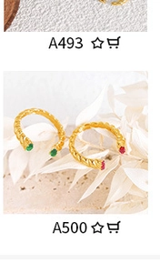 Macro shot of twisted gold bangle featuring red and green oval gemstone accents