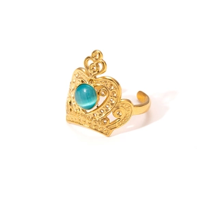 Detail of crown-shaped gold ring with an oval blue cat-eye stone on white background
