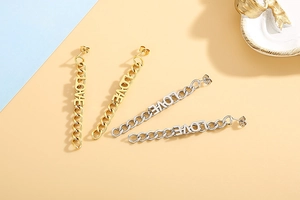 Detail of gold and silver chain drop earrings featuring LOVE letter design and long tassels