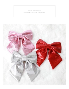 Close-up of pink, silver, and red sequin bows on a white faux fur background