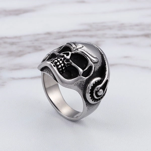 Anello gotico punk teschio con cuffie in argento vintage su fondo marmo