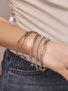 Close-up of four-piece silver stainless steel bracelet set with twist and mesh detail