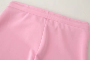 Detail of pink elastic waistband with reinforced stitching on high-waist flared pants