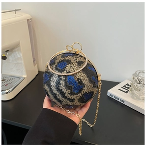 Detail of spherical leopard print evening bag with sequin finish and gold ring handle