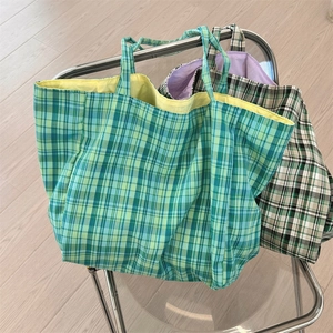 Gros plan de sacs fourre-tout en toile à carreaux élégants dans un cadre de vie.