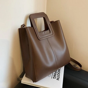 Dettaglio della borsa in pelle PU marrone scuro con l'esclusivo manico quadrato traforato