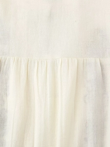 Macro shot of breathable cream-colored cotton fabric texture with pleated sewing details