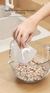 Close-up of a white snap-on strainer clip with fine mesh holes on a glass bowl for draining