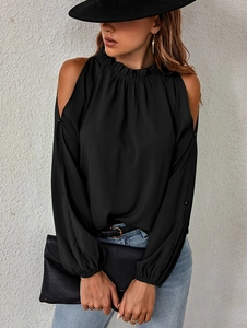 Detail of elegant black ruffles on a high collar cold shoulder long sleeve blouse