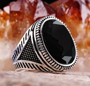 Macro view of vintage silver ring with faceted black onyx and ornate side engravings