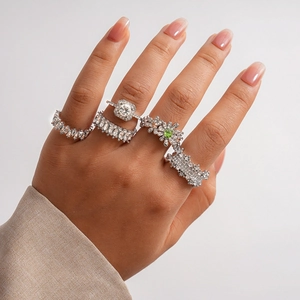 Detail of 5-piece silver ring set featuring square floral and green zircon accents