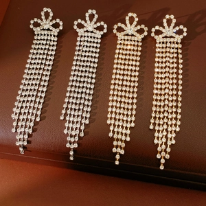 Dettaglio di orecchini vintage con lunghe nappe in argento e oro con strass scintillanti