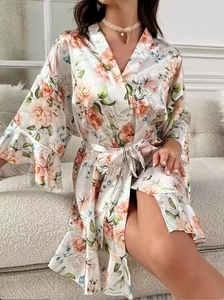 Détail du peignoir en satin imprimé floral avec manches à volants sur un canapé chic