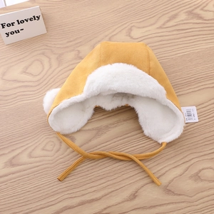 Detailed view of yellow winter trapper hat with soft white faux fur lining and chin straps