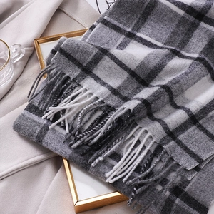Close-up of grey and white wool scarf with checkered pattern and fringe details