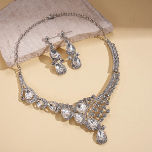 Silver teardrop crystal necklace and earrings jewelry set for women on stone display