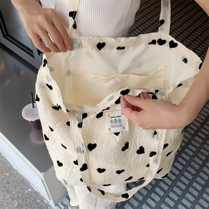 Detail showing the inner lining and pocket of the textured heart print tote bag