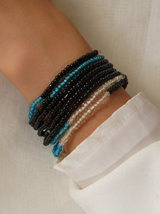 Close-up of stacked handmade bohemian glass seed bead waist chains on a wrist