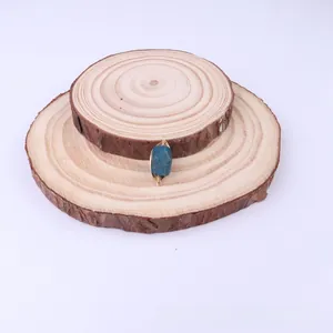 Detail of handmade wire wrapped blue natural stone pendant with gold wire weaving finish