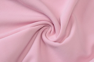 Gros plan sur la texture du tricot rose montrant l'élasticité et le détail du tissu doux