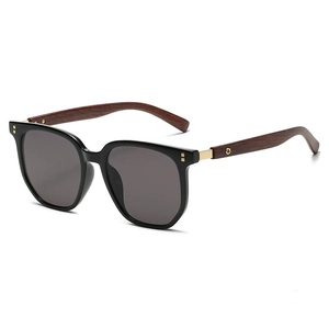 Detail of wooden grain temples on vintage oversized sunglasses with golden hinge accents