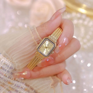 Elegant gold square watch for women with diamond-encrusted bezel and mesh band on wrist