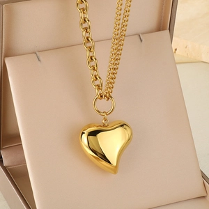 Close-up of golden heart pendant necklace with double-layer chain in a jewelry box